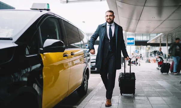 Homme d'affaires à l'aéroport à côté d'un taxi